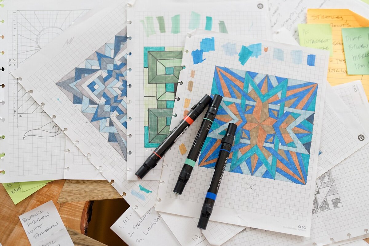 paper with designs and pens on a table top for branding photos