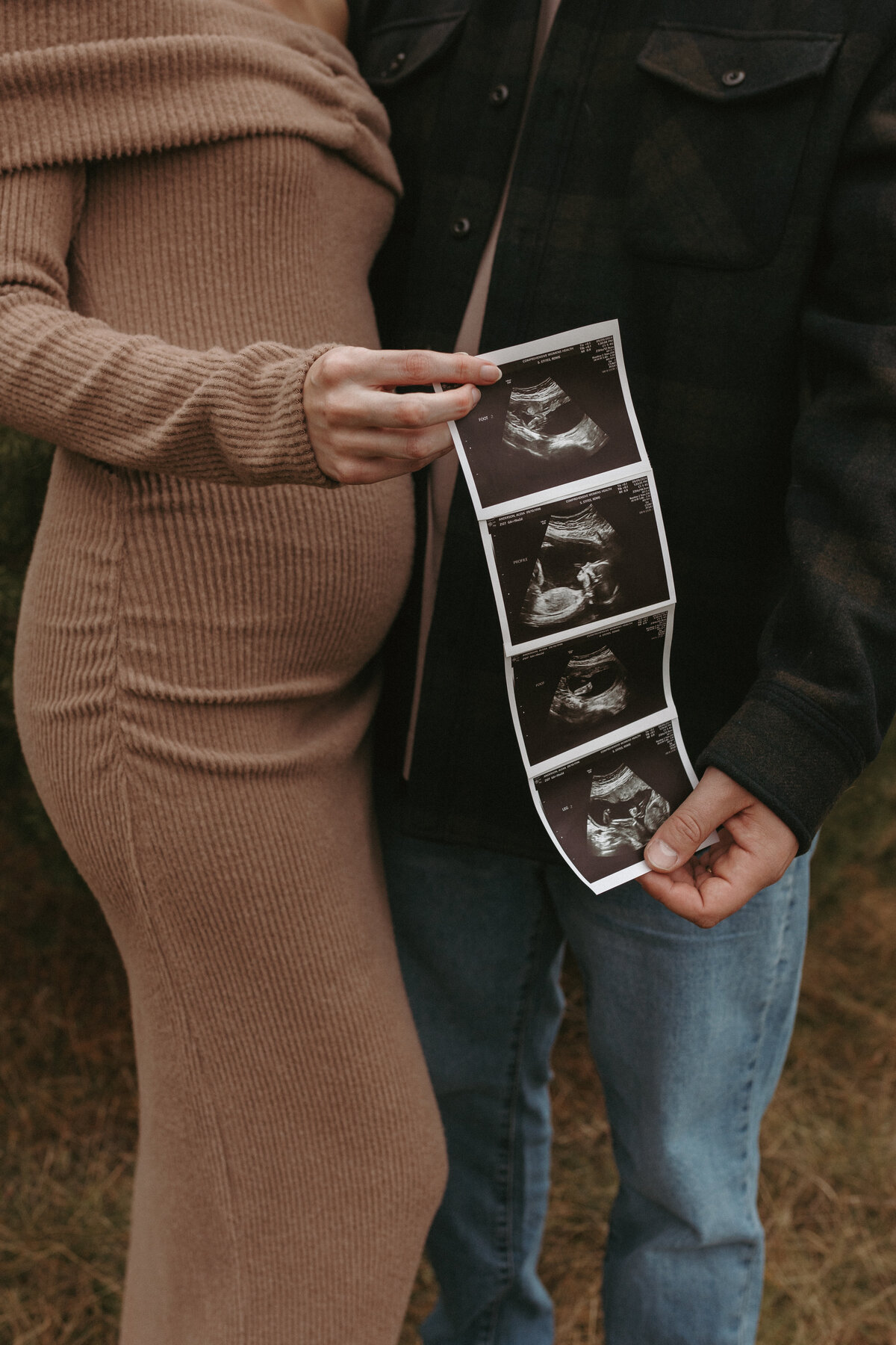 Couple holding an ultrasound photo during their Michigan session