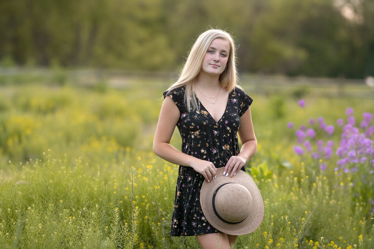 senior girl with blonde hair in field of wildflowers