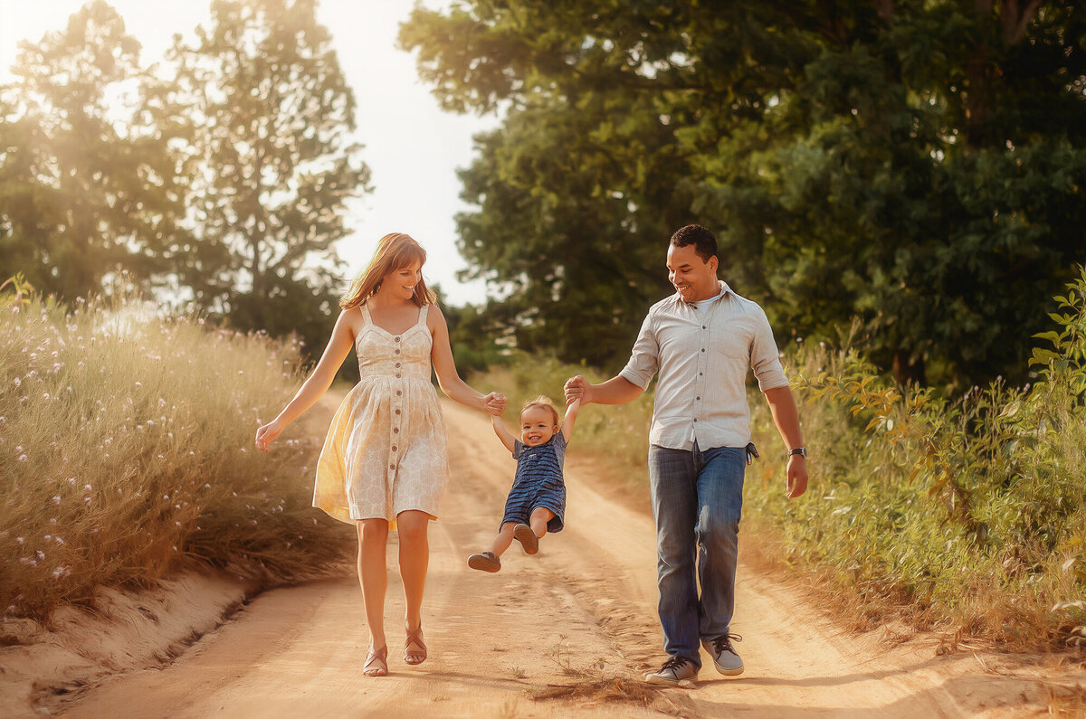 Family walks along a dirt road during Family Photoshoot in Asheville, NC.