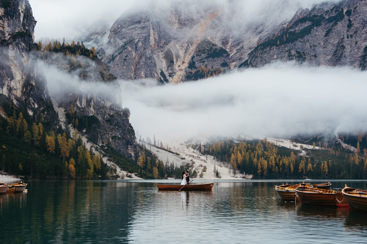 Single rowboat on calm Lago di Braies reflecting mountains