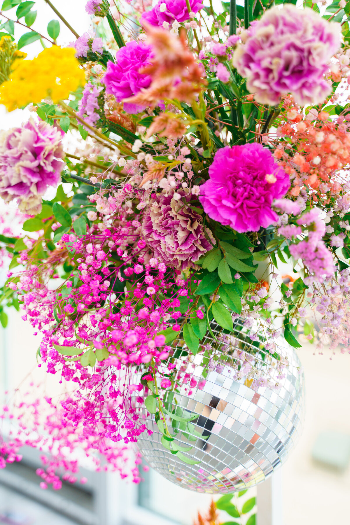 Colorful, whimsical floral arrangement with a disco ball at a wedding at North 4th Corridor (The Revery) in Columbus, Ohio.