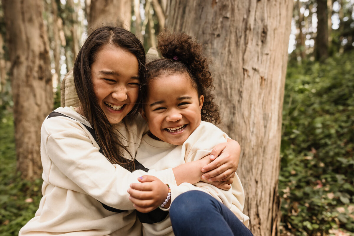 Biracial sisters portrait smiling and hugging