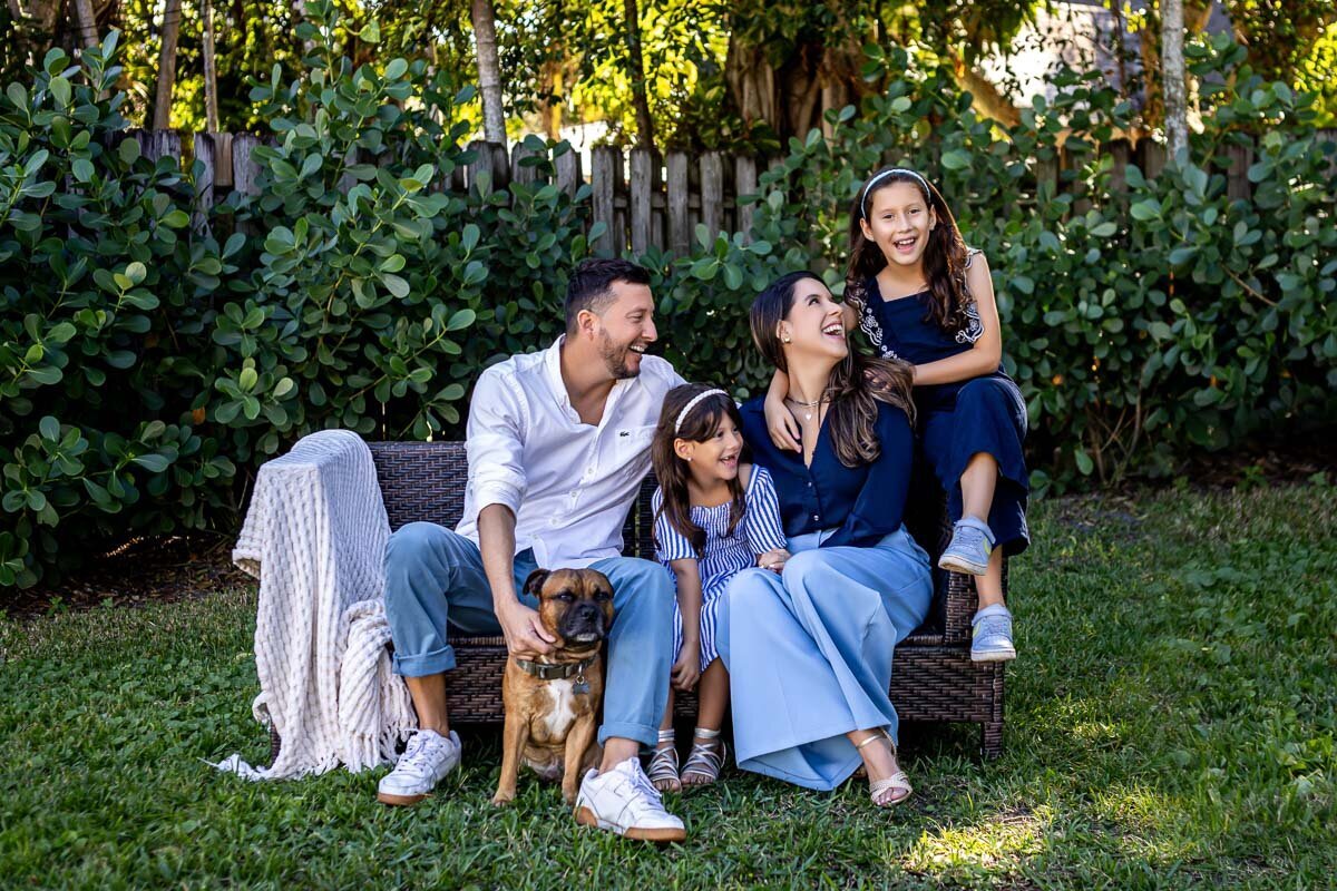 Family sitting in backyard laughing 