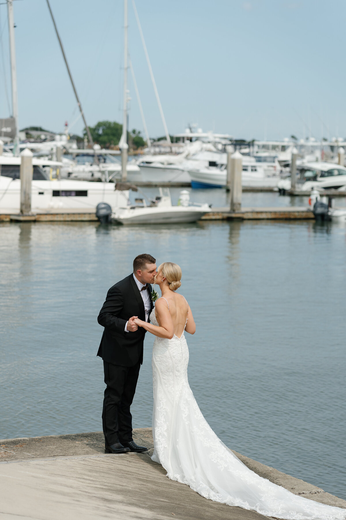 Film wedding photography of bride and groom kissing in front of marina by Shelby Ann Photos