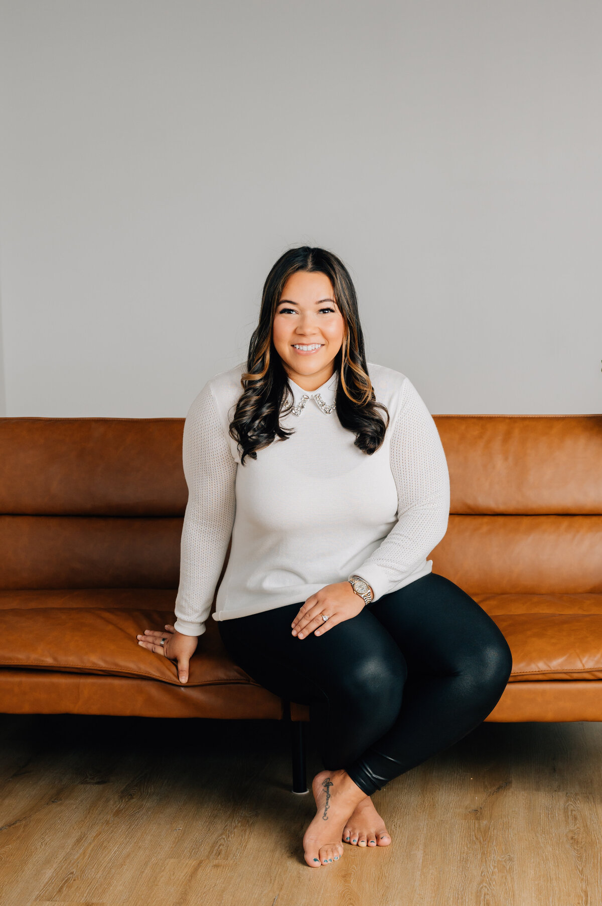 Headshot of smiling woman on couch by lifestyle branding photographer in Houston