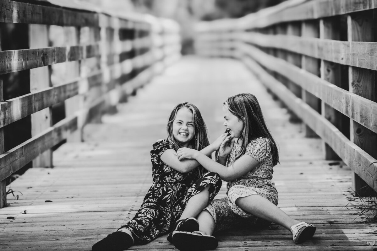twins-laughing-together-on-a-bridge
