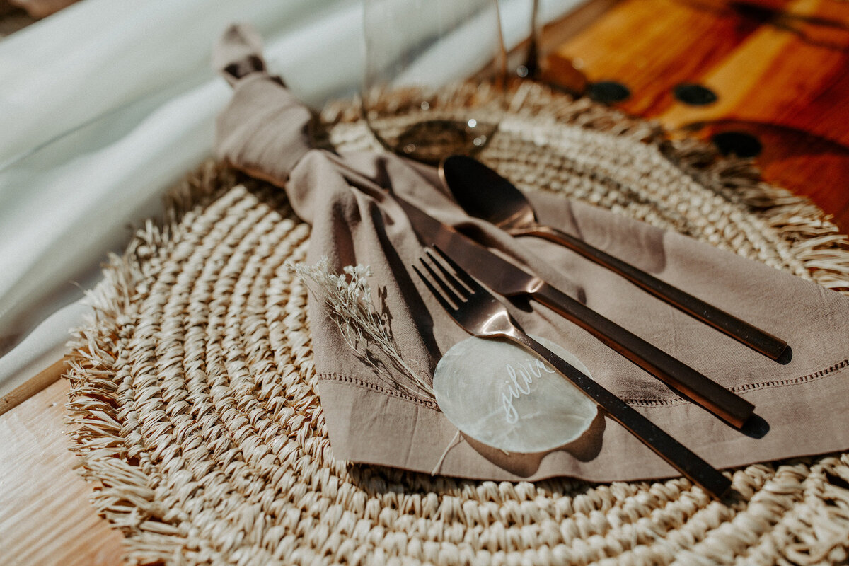 Boho tablescape for an outdoor ranch wedding, with capiz shell calligraphy place cards
