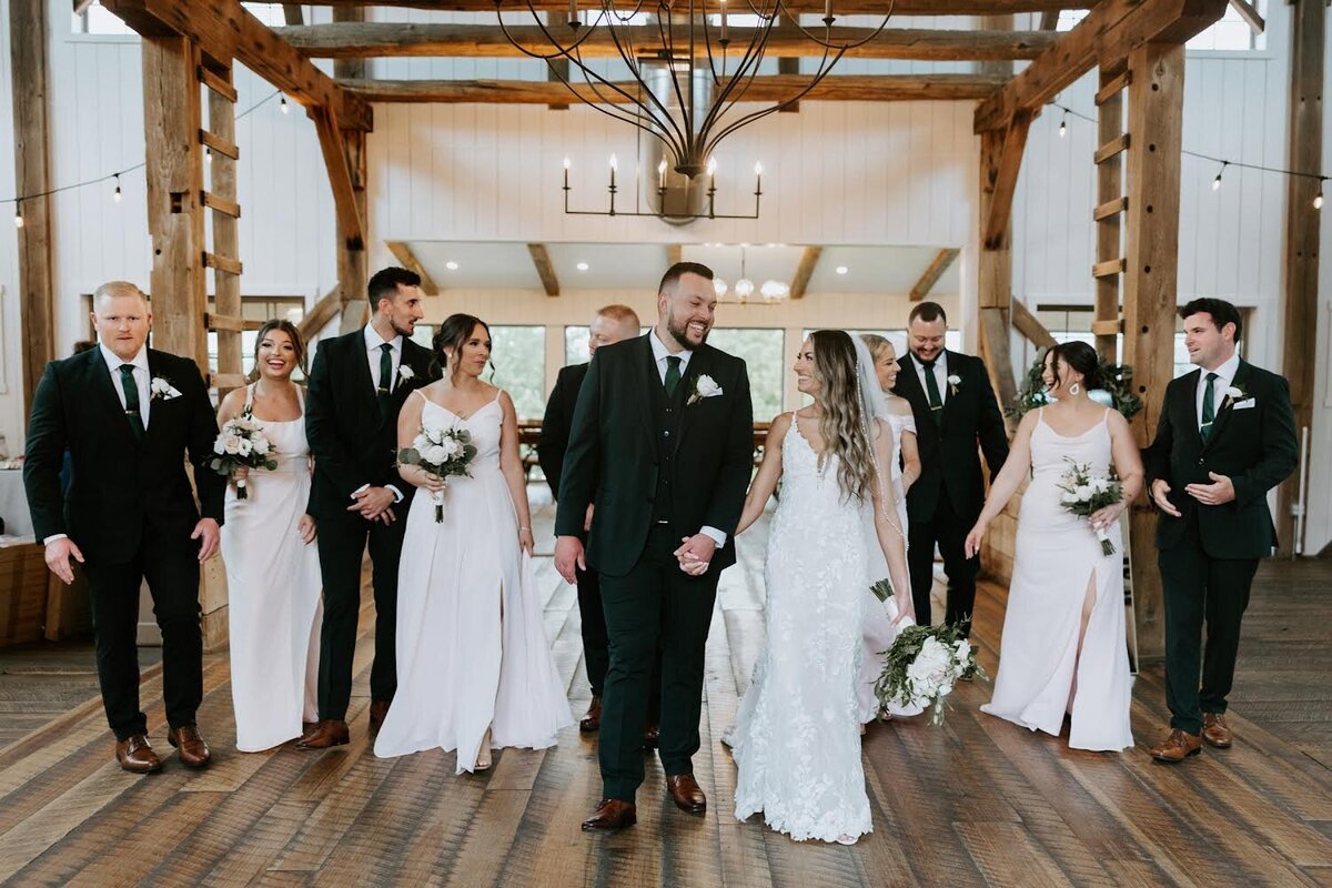 color image of bride and groom and their wedding party dressed in pink gowns and black tuxedos in the Willowbrook wedding upscale venue