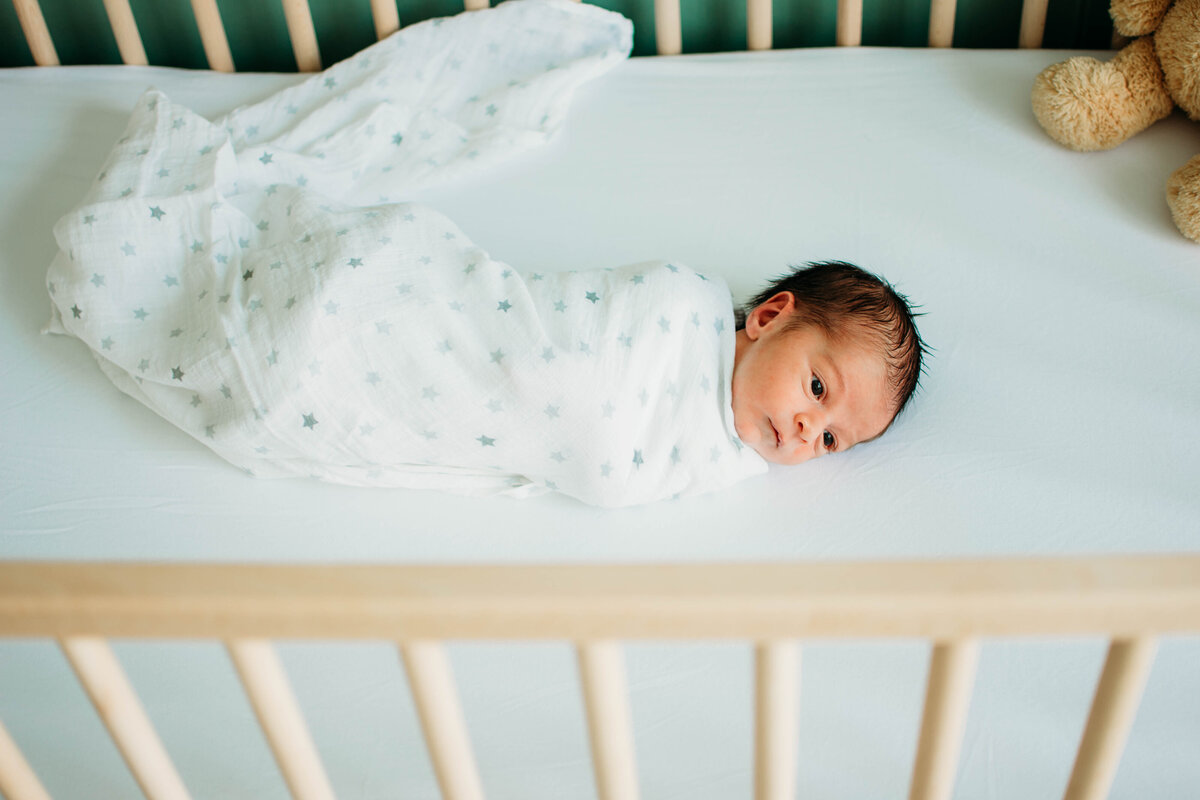 baby boy swaddled in his crib during a photo shoot in Bartlett, IL