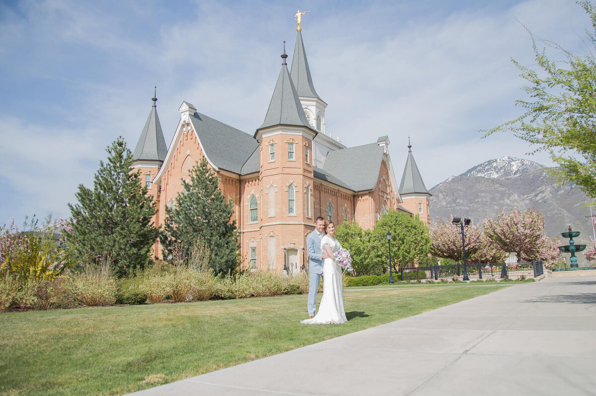 portrait of a wedding couple by a brick building