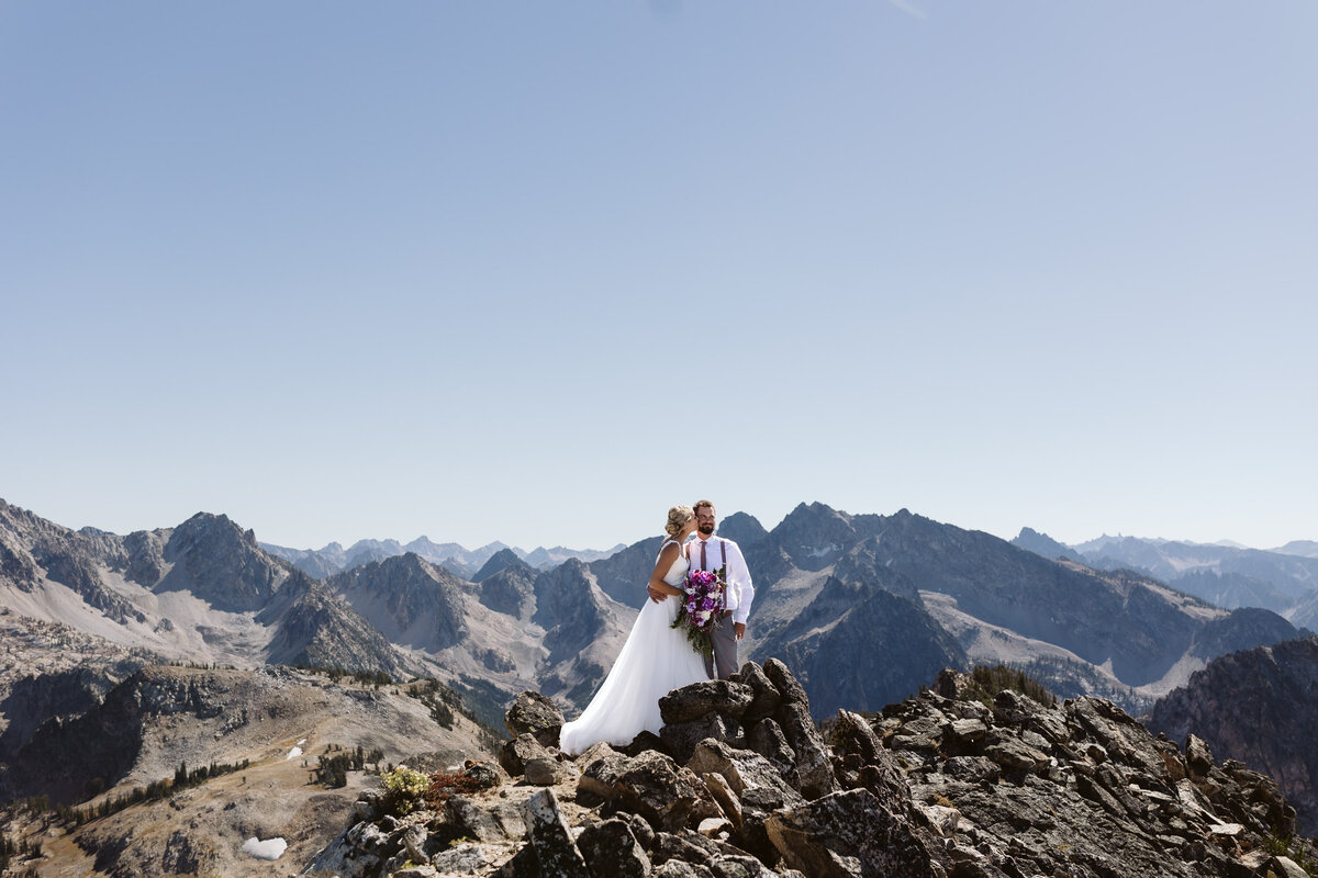 a couple standing on top of a mountain in the Sawtooth Mountain Range near stanley, idaho