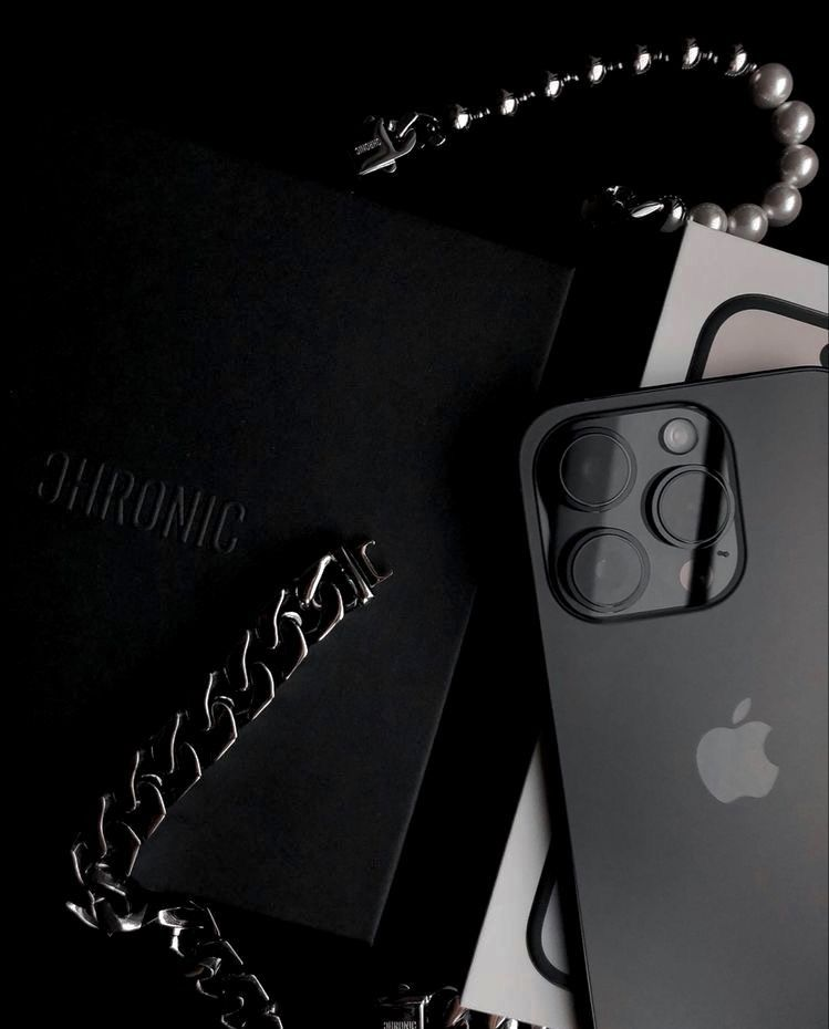 Luxury flatlay with black iPhone and designer bag chain, symbolizing sophistication, freedom, and success — reflecting Ayah Official’s mentorship for modern entrepreneurs ready to build profitable online brands.