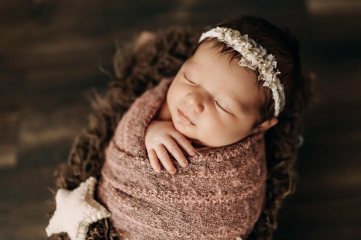 Newborn baby girl wrapped in pink