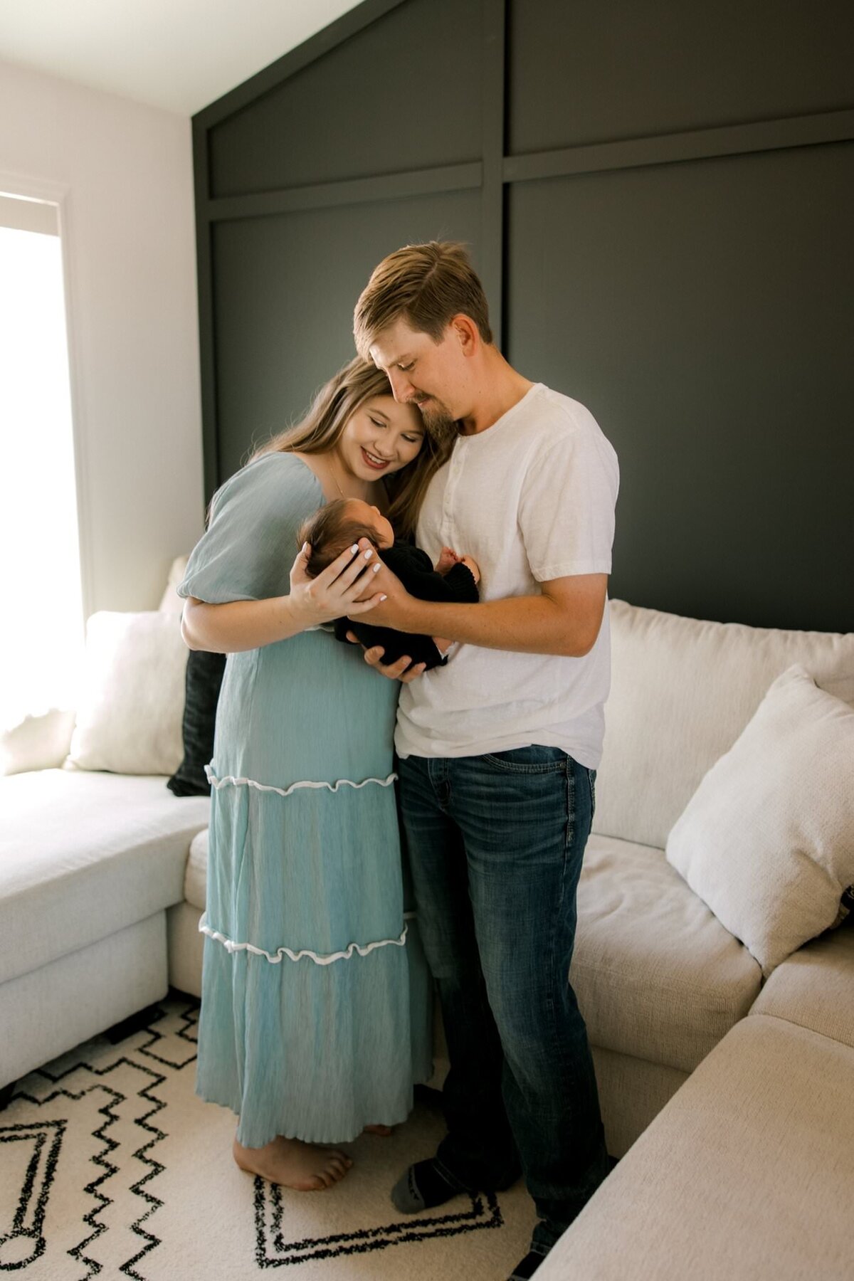 Couple holding their newborn in their living room.