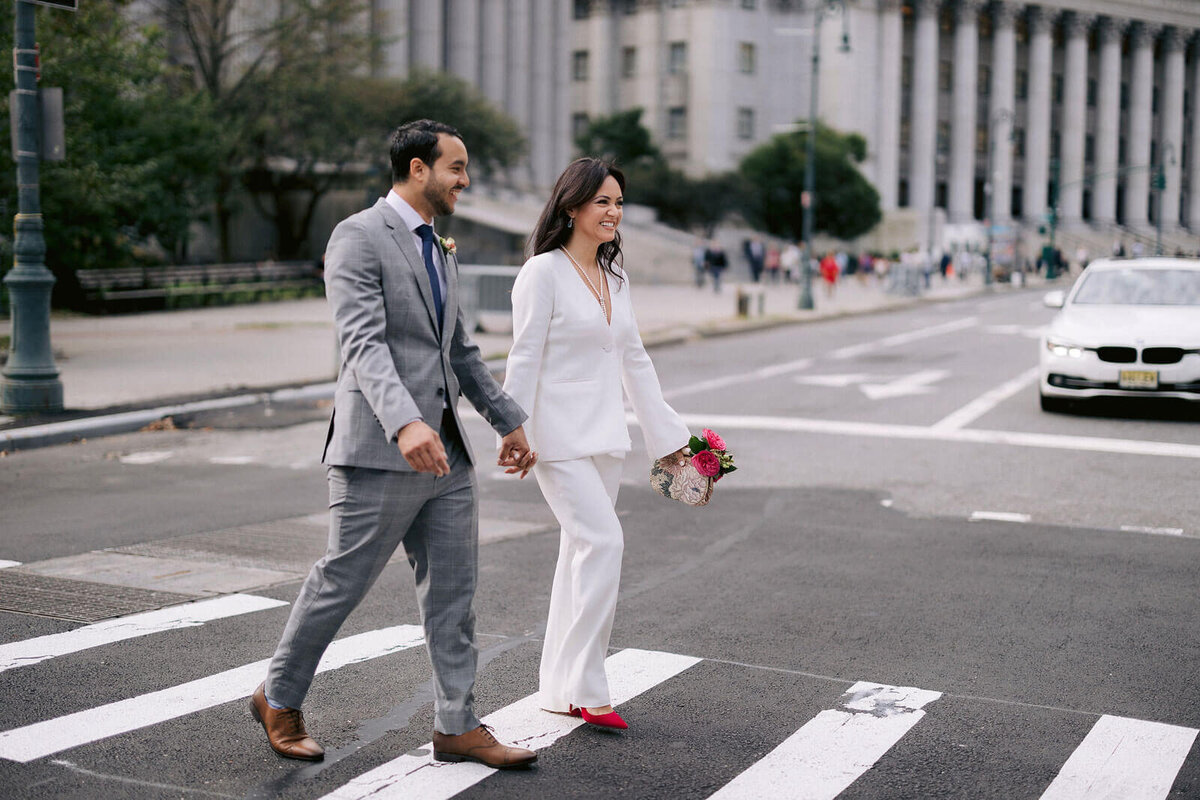 The bride and groom are crossing the street, heading over to New York City Hall for their elopement. Image by Jenny Fu Studio