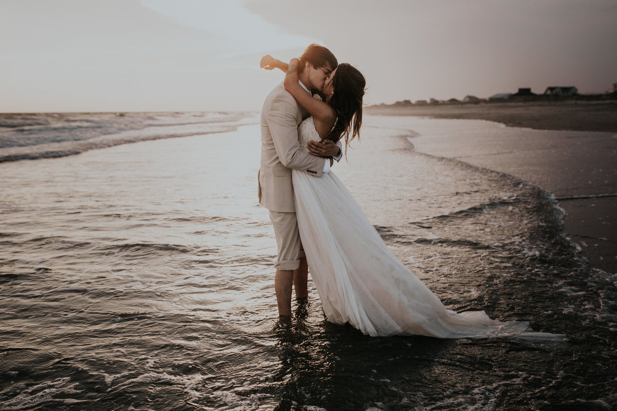 Bride and Groom kissing in the ocean on Bald  Head Isalnd
