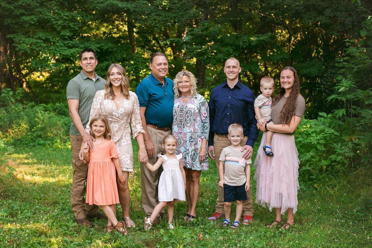 A-multi-generational-family-posing-together-in-a-lush-green-setting-during-a-loving-extended-family-photo-session-at-Glenns-Valley-Nature-Park-in-Greenwood-Indiana-one-of-my-favorite-locations