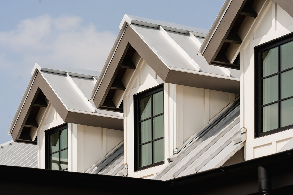 dormer windows with white board and batten and metal standing seam roof