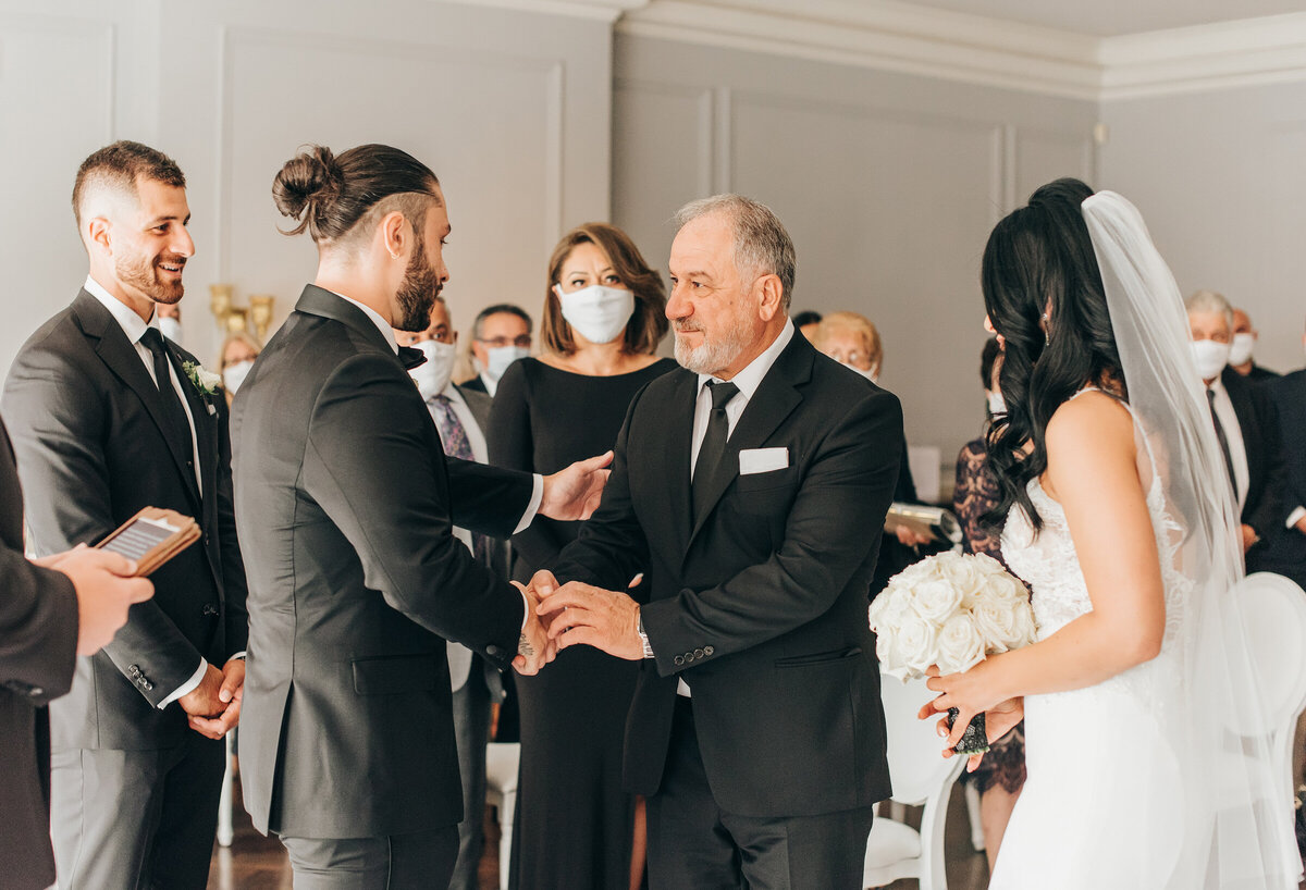 Father giving away the bride at a black tie wedding ceremony