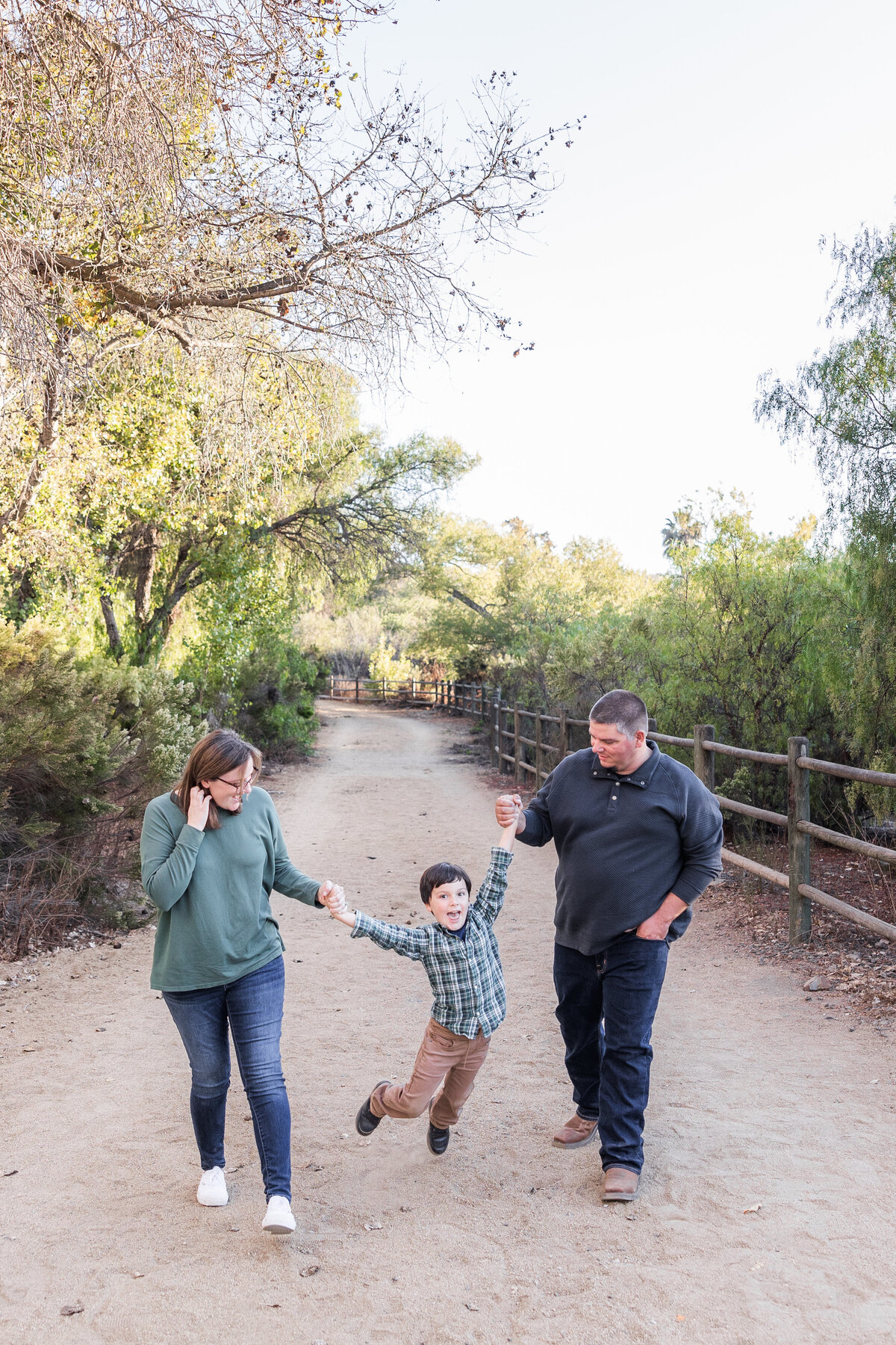 parents walking son on trail in san diego bonita