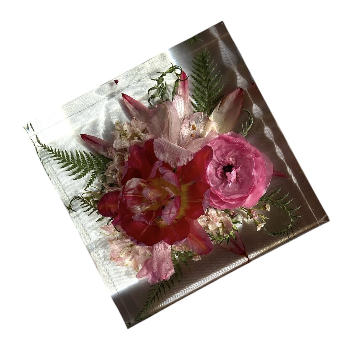 square resin block with bright pink  funeral flowers preserved as a family heirloom