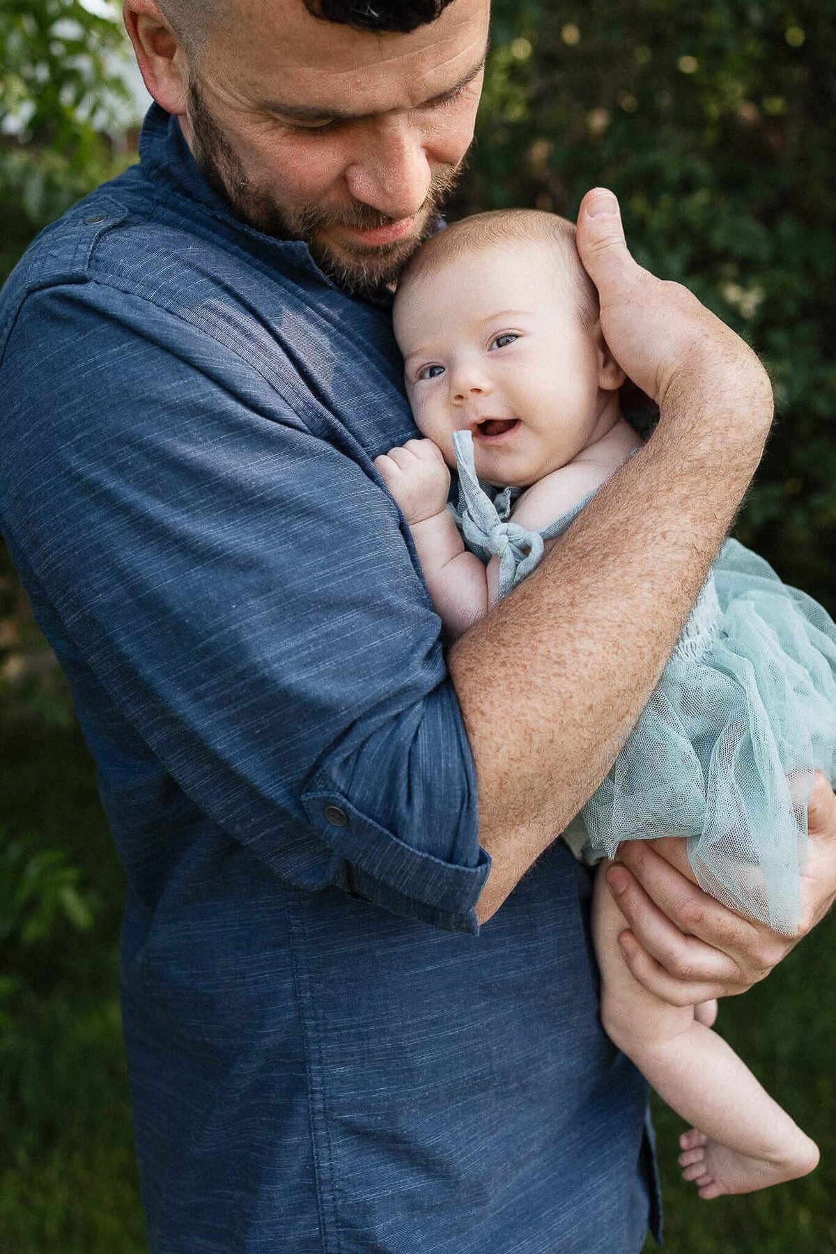 A sweet father-baby moment in backyard during Cleveland family photography session at home.