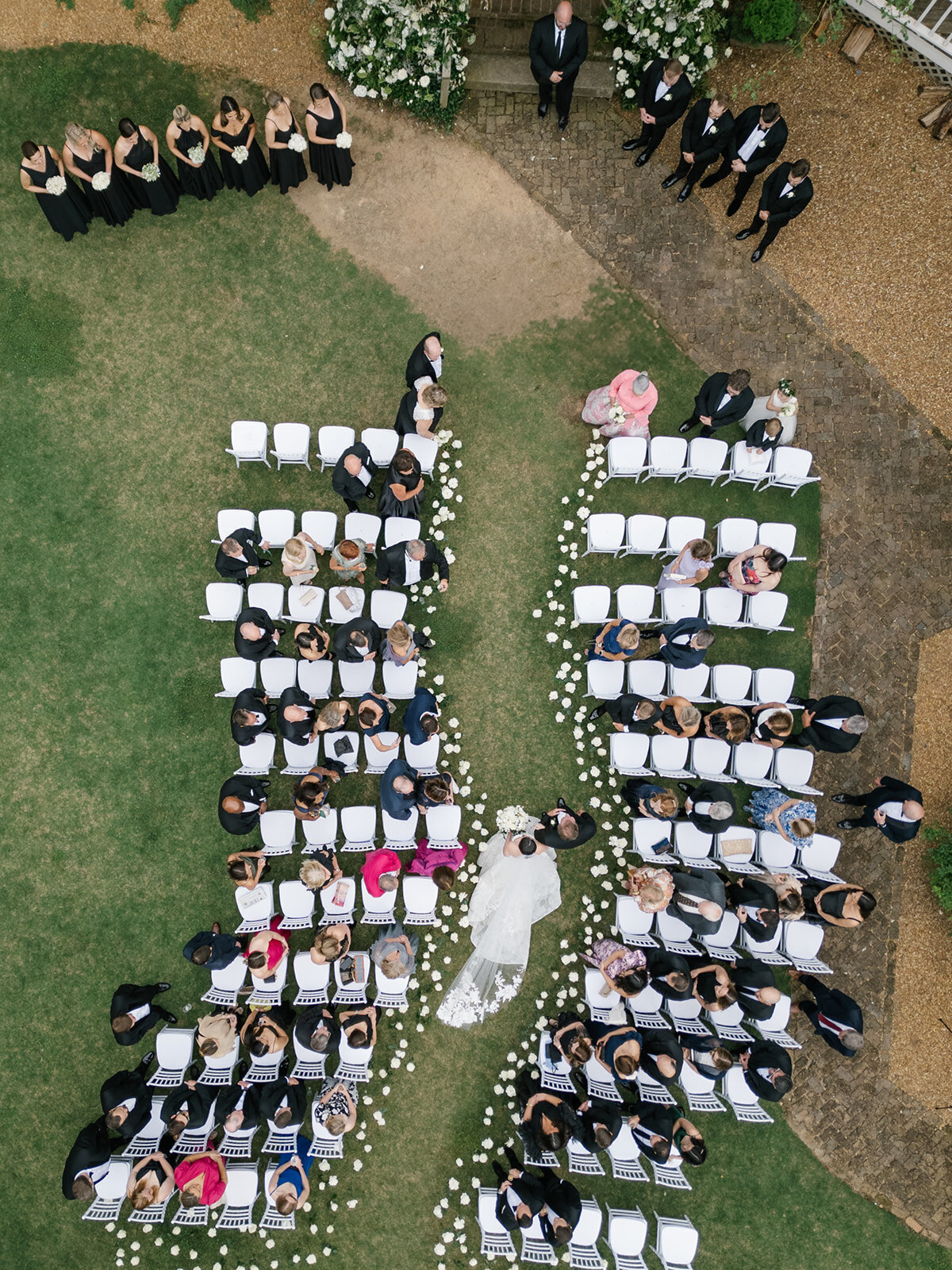 white roses sticking in ground for wedding aisle