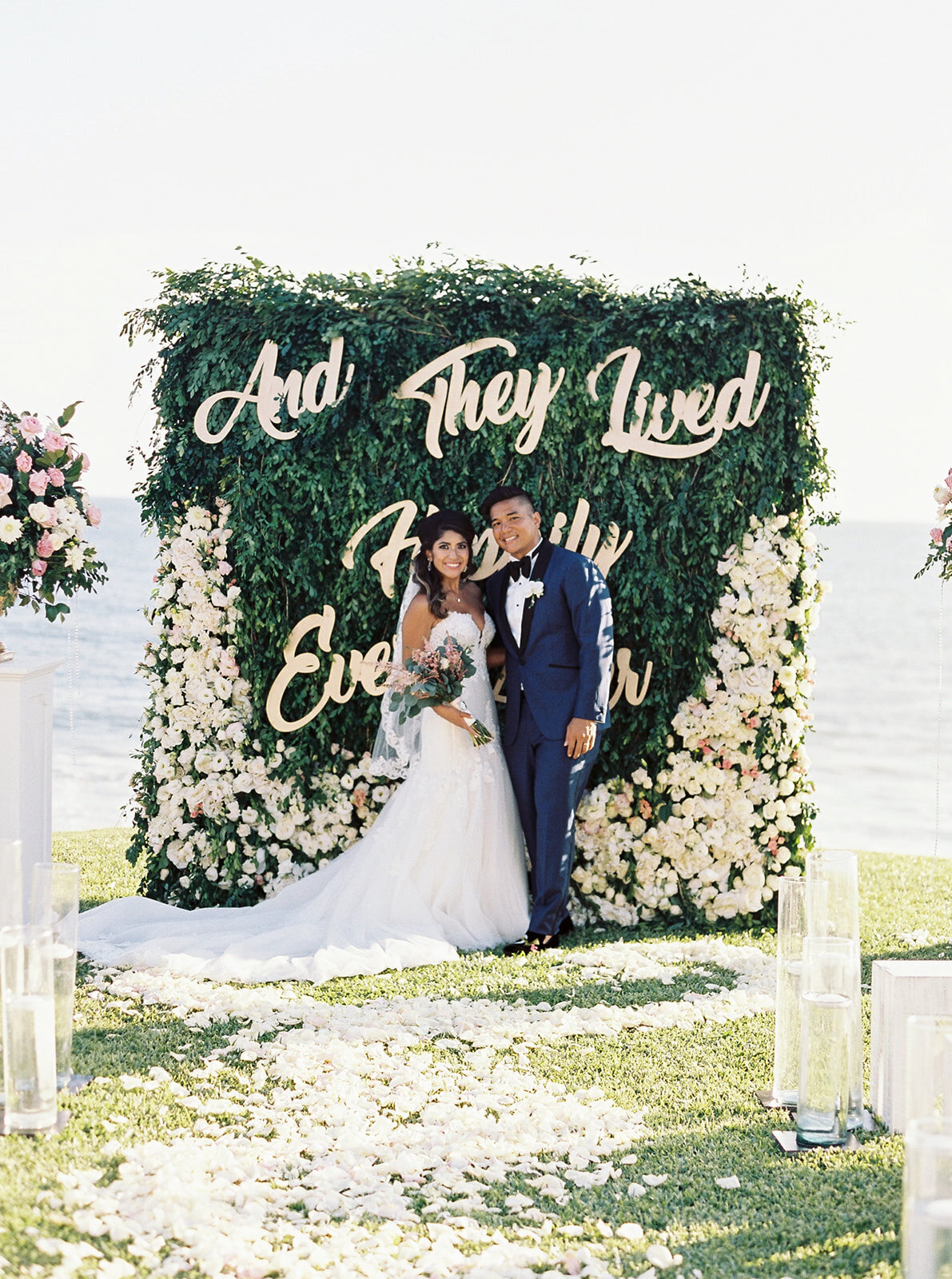 bride and groom standing in front of a happily ever after sign