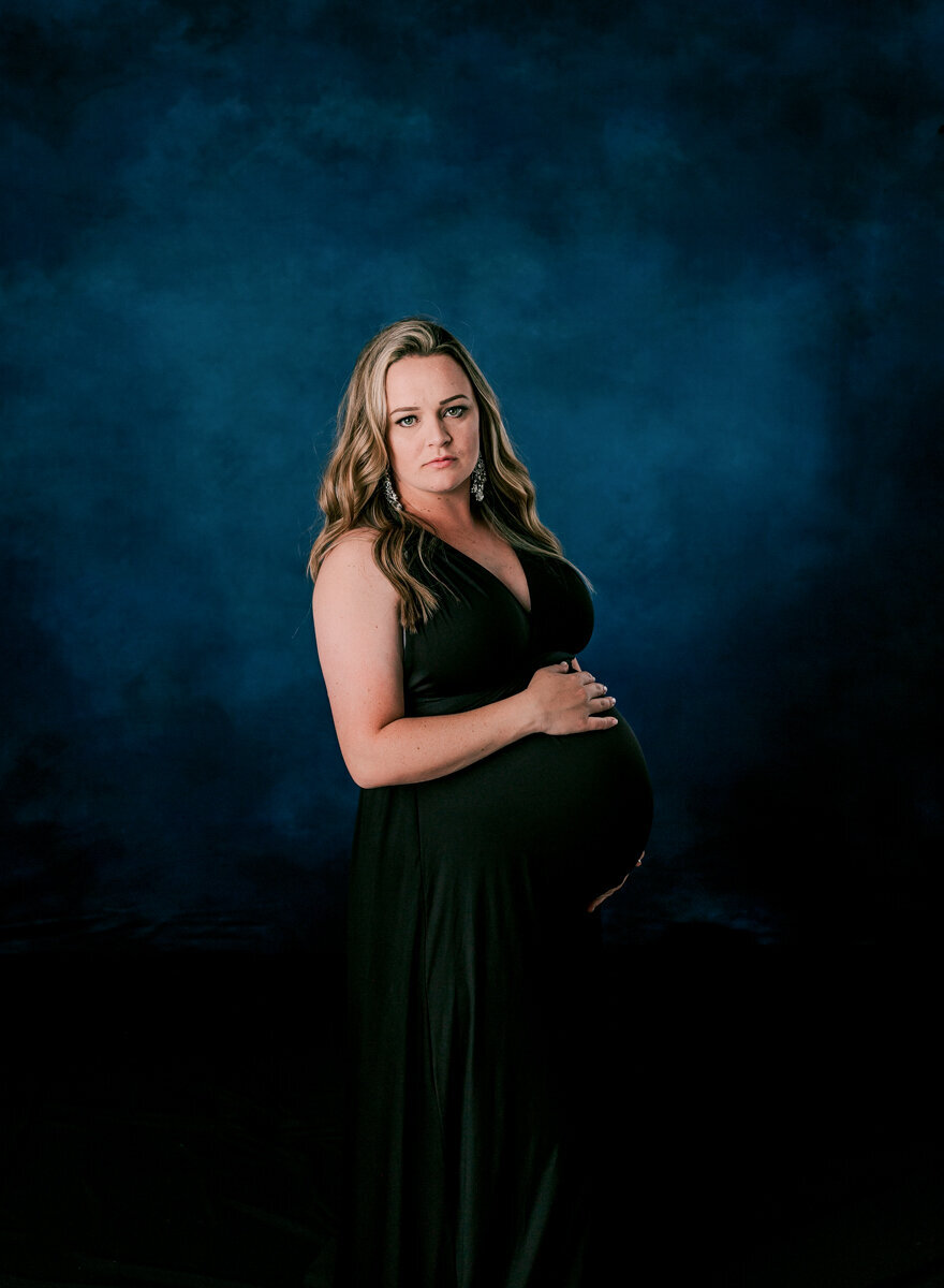 Stunning blue studio backdrop for a maternity photo.