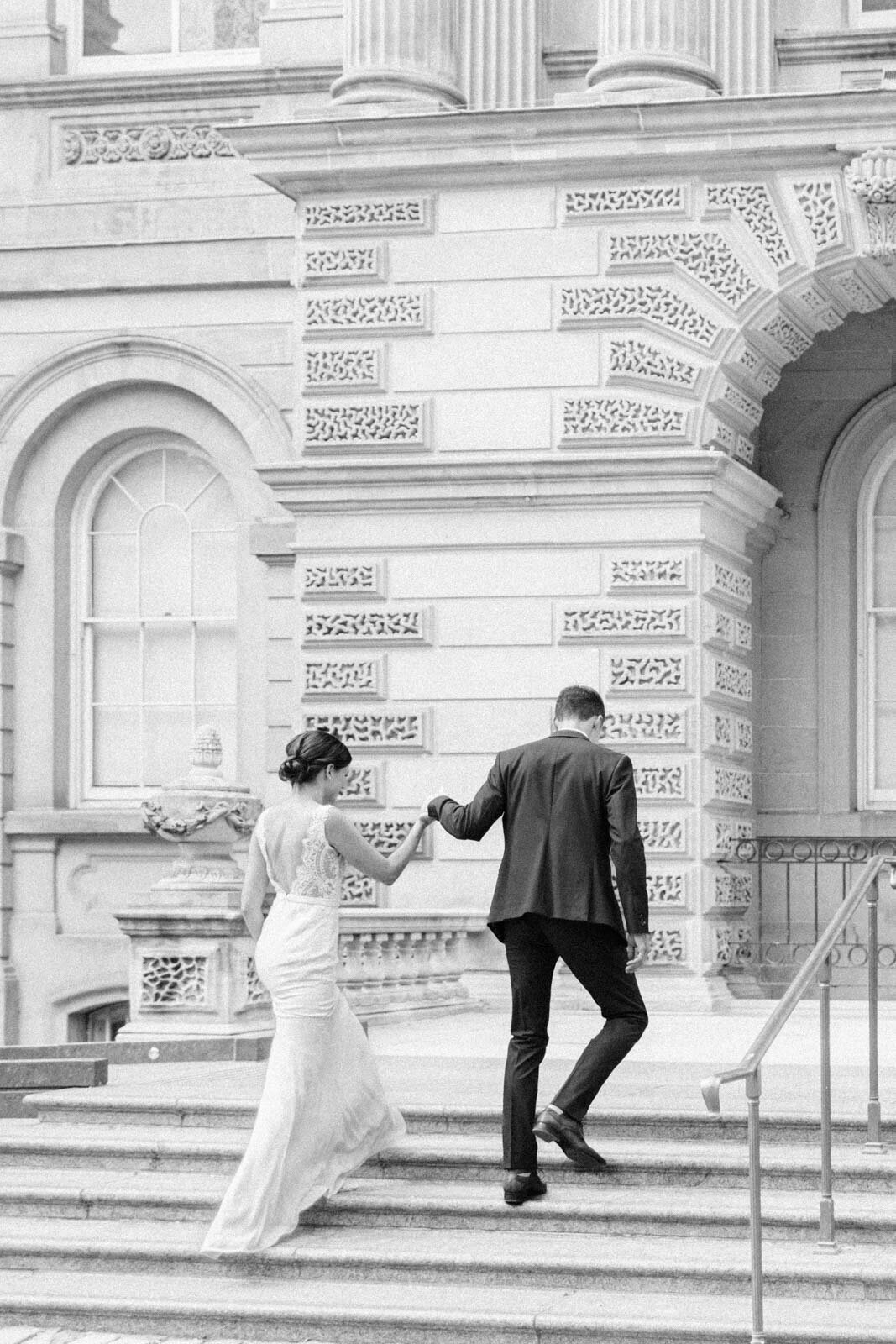 Couple walking up stairs together on wedding day captured  by the best Calgary Wedding Photographer