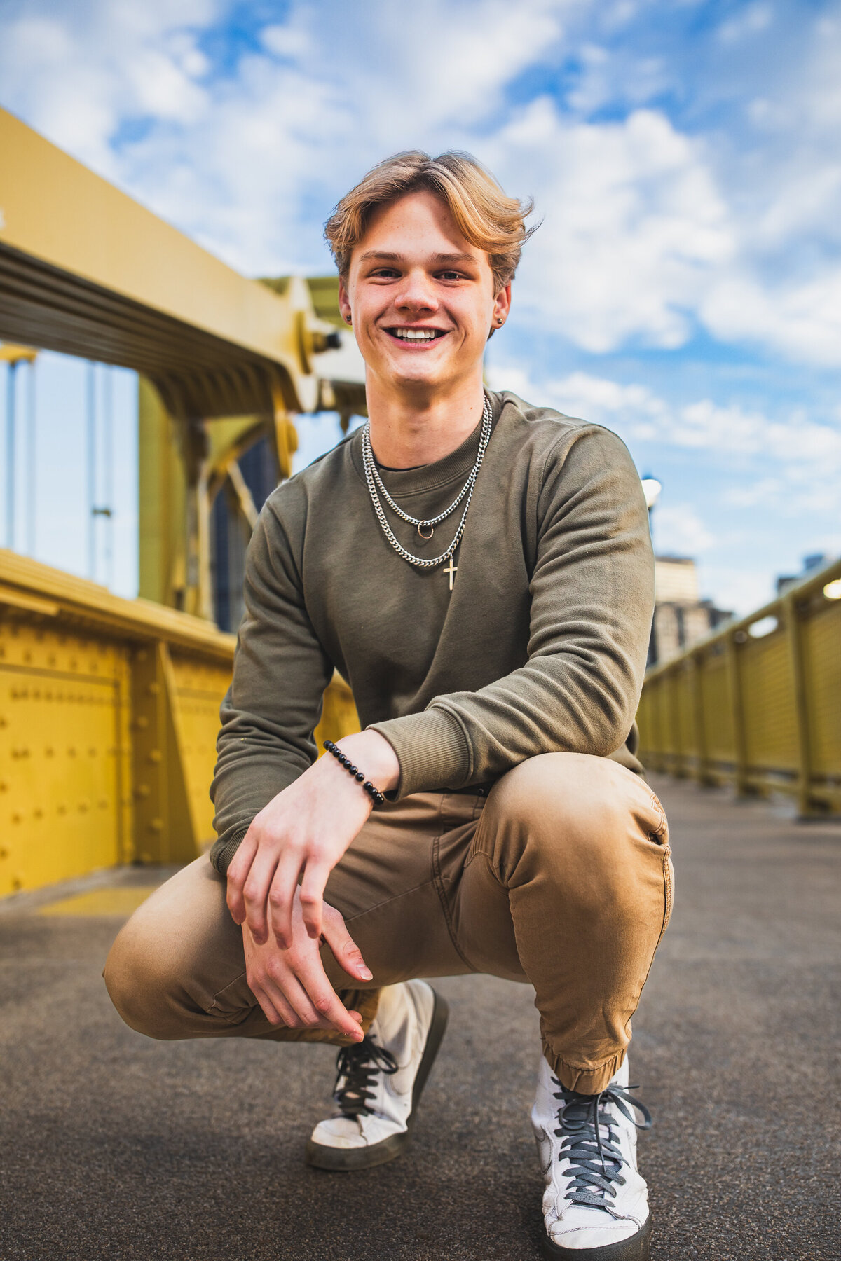 This Blonde senior boy from Pittsburgh PA poses on the ROBERTO Clemente Bridge for his senior photos.