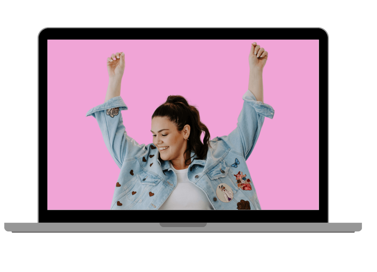 laptop showing woman with dark hair throwing hands up celebrating in jean jacket