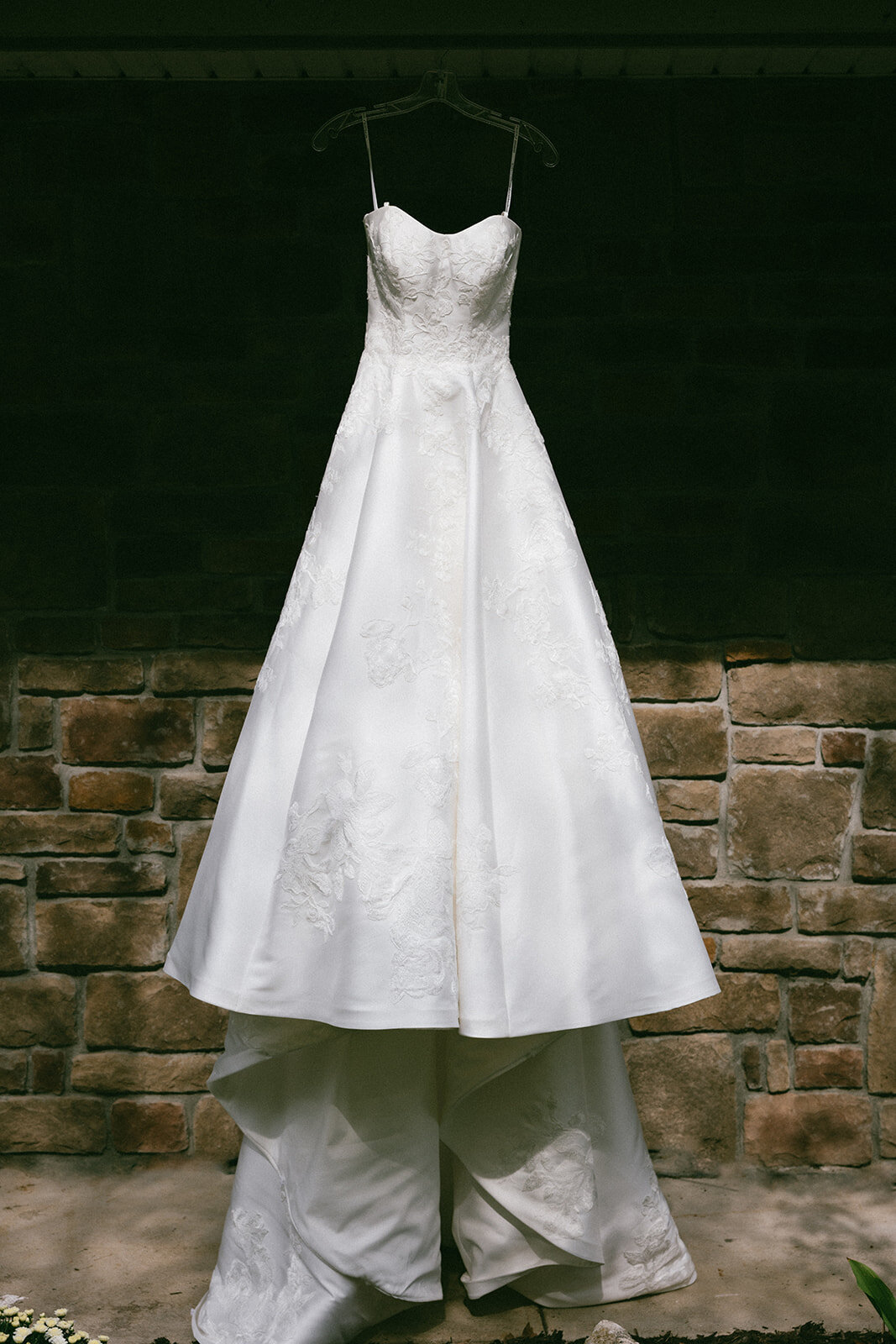 Bride's gown hangs in dramatic sunlight at her childhood home on Long Island. 