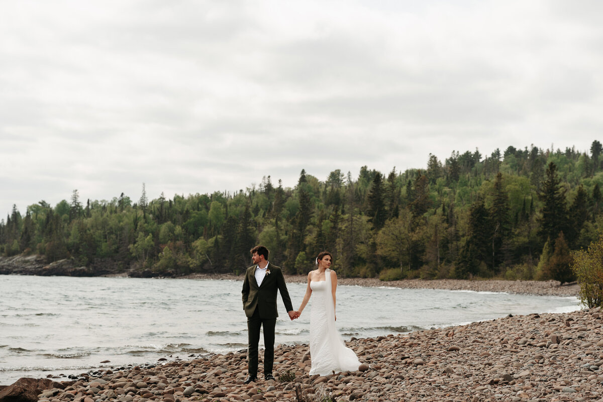 Bride and groom holding hands by the lake by Kelly Friday, Wedding Photography Minneapolis. 