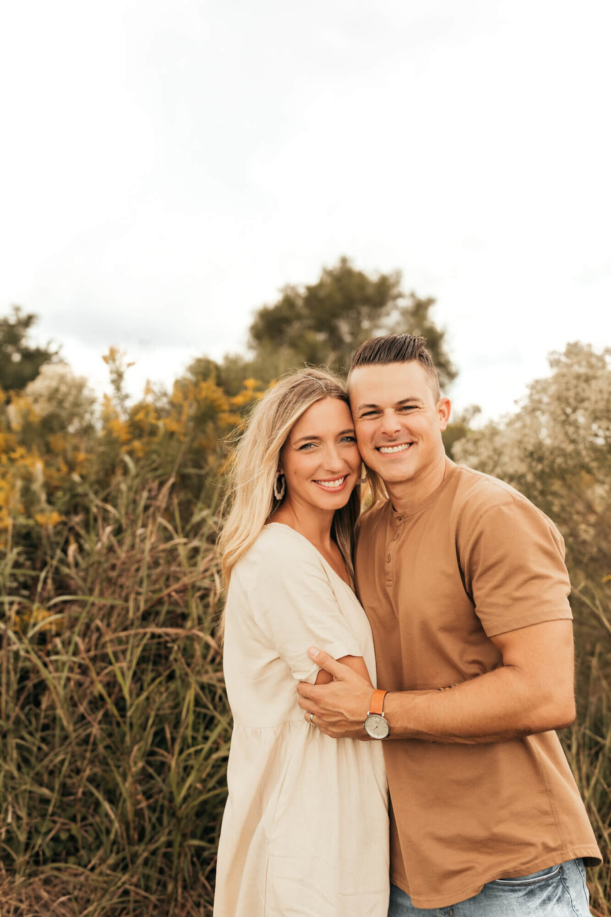 husband and wife take photograph next to each other during fall session