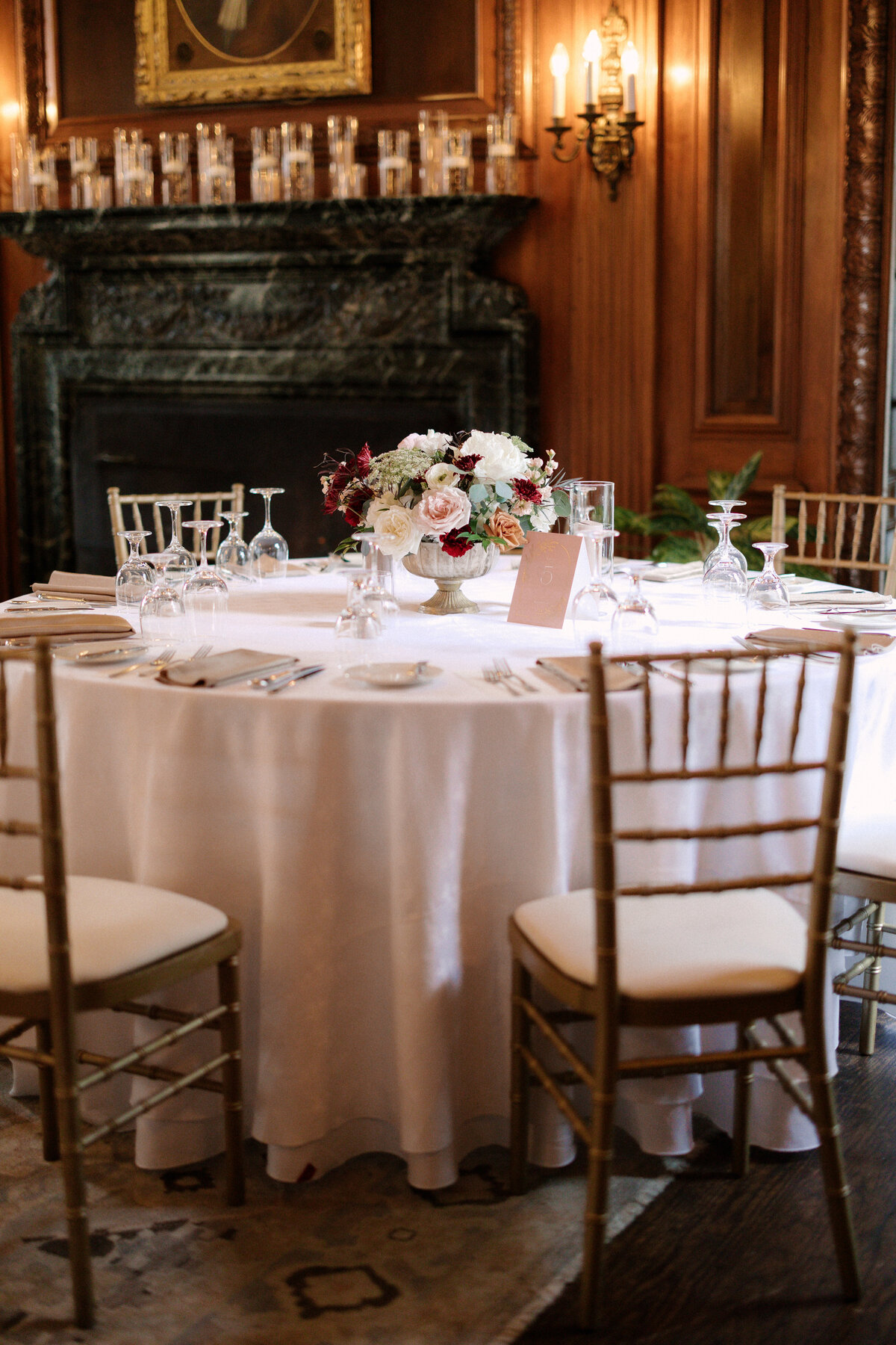 November wedding at Graylyn Estate, designed and planned by Charming Carolina — indoor dinner table setup with white linens and a floral centerpiece in the manor house.