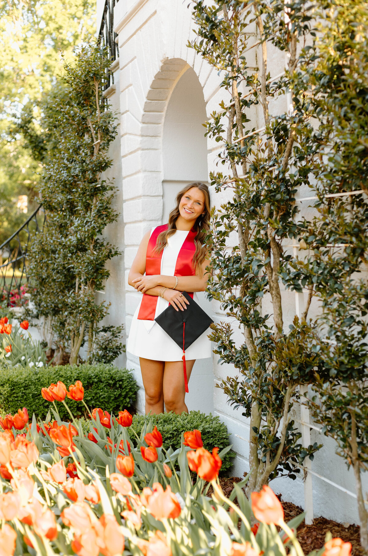 Graduate in a white Dress posed infront of the President's Mansion