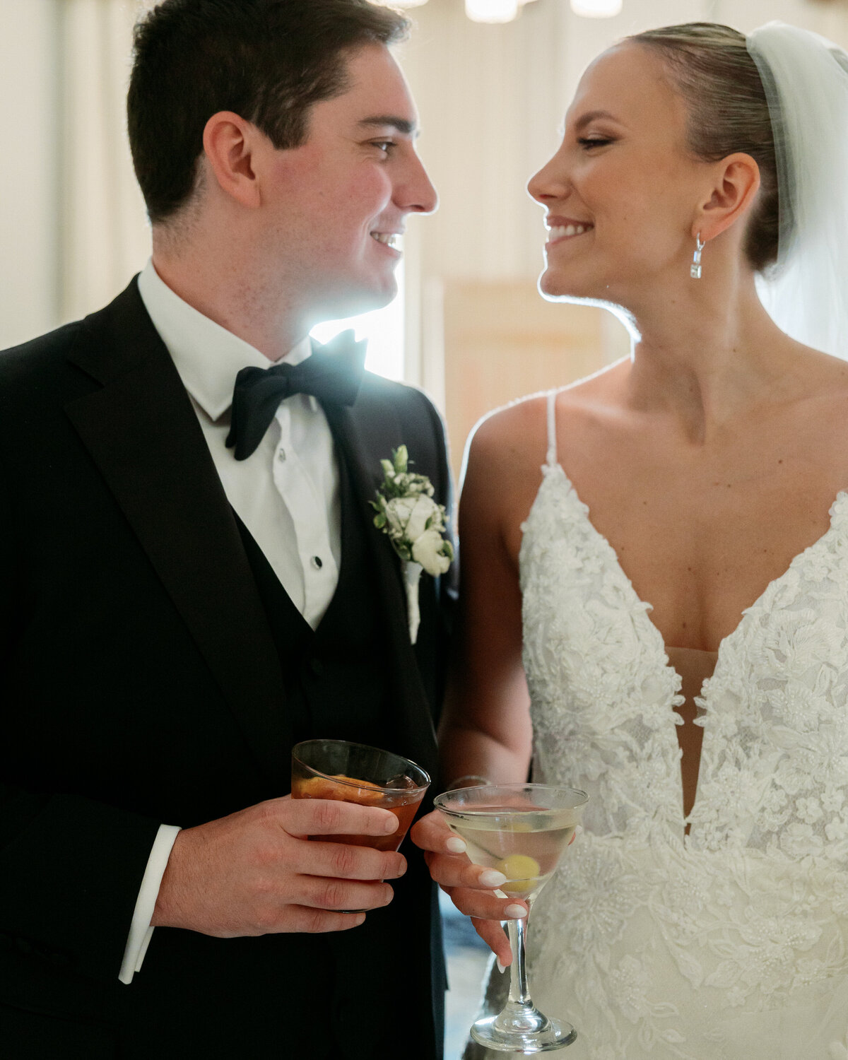 Bride and groom share drinks post-ceremony, smiling at each other, by Philadelphia wedding photographer.