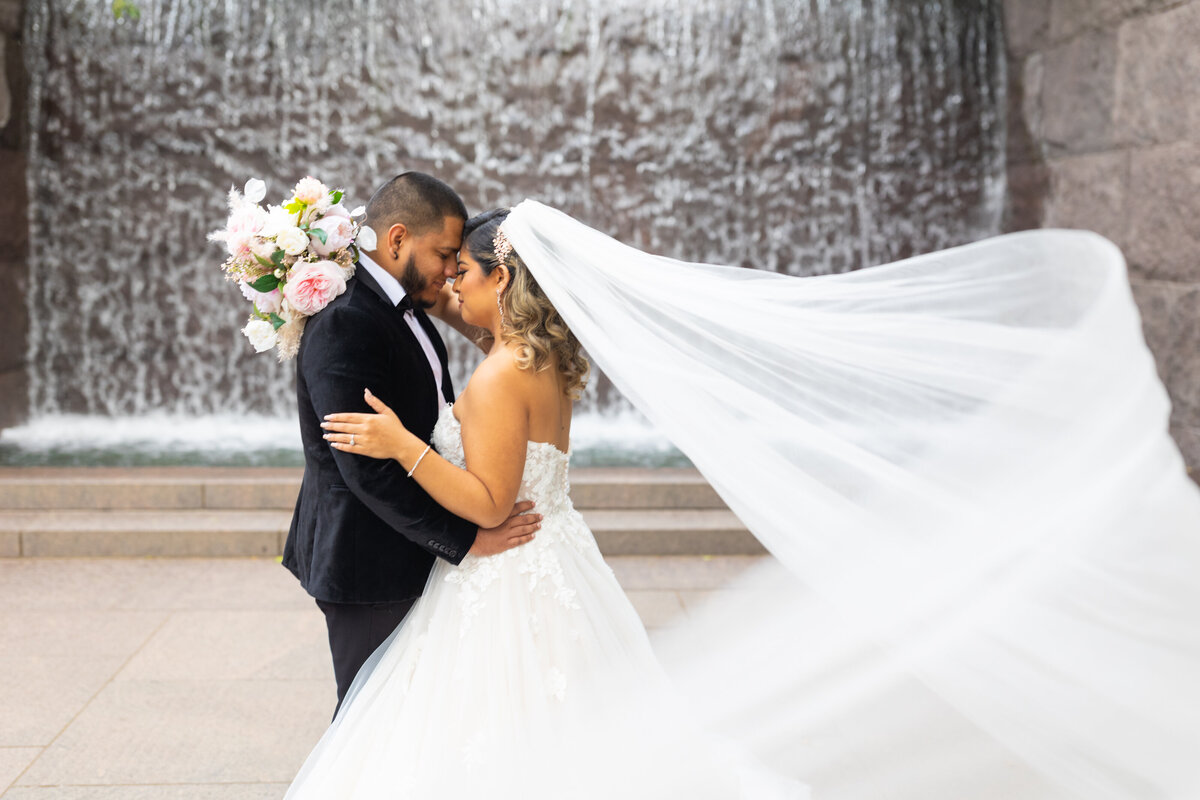 bride and groom holding each other while veil blows in wind in Orlando Florida by Orlando wedding photographer Amanda Richardson Photography