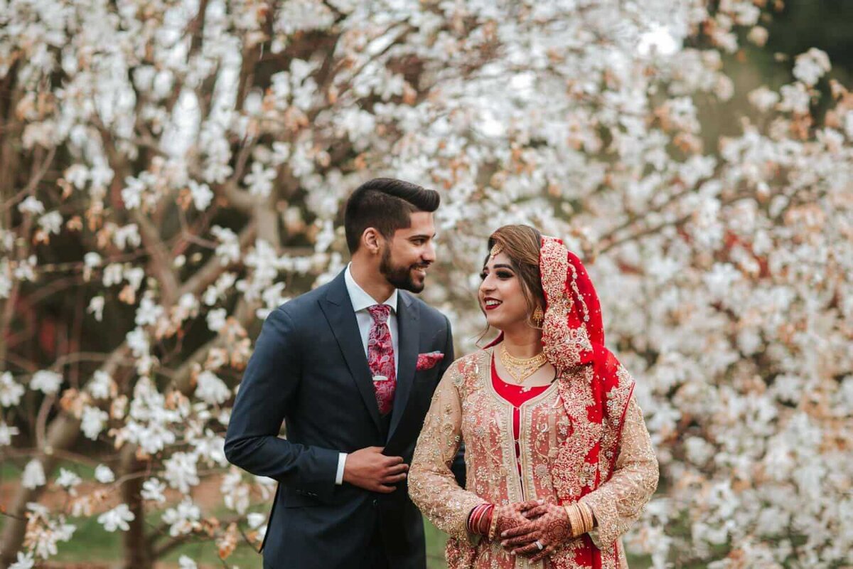 South Asian couple excited for the day to come surrounded by white florals in New Brunswick, new jersey