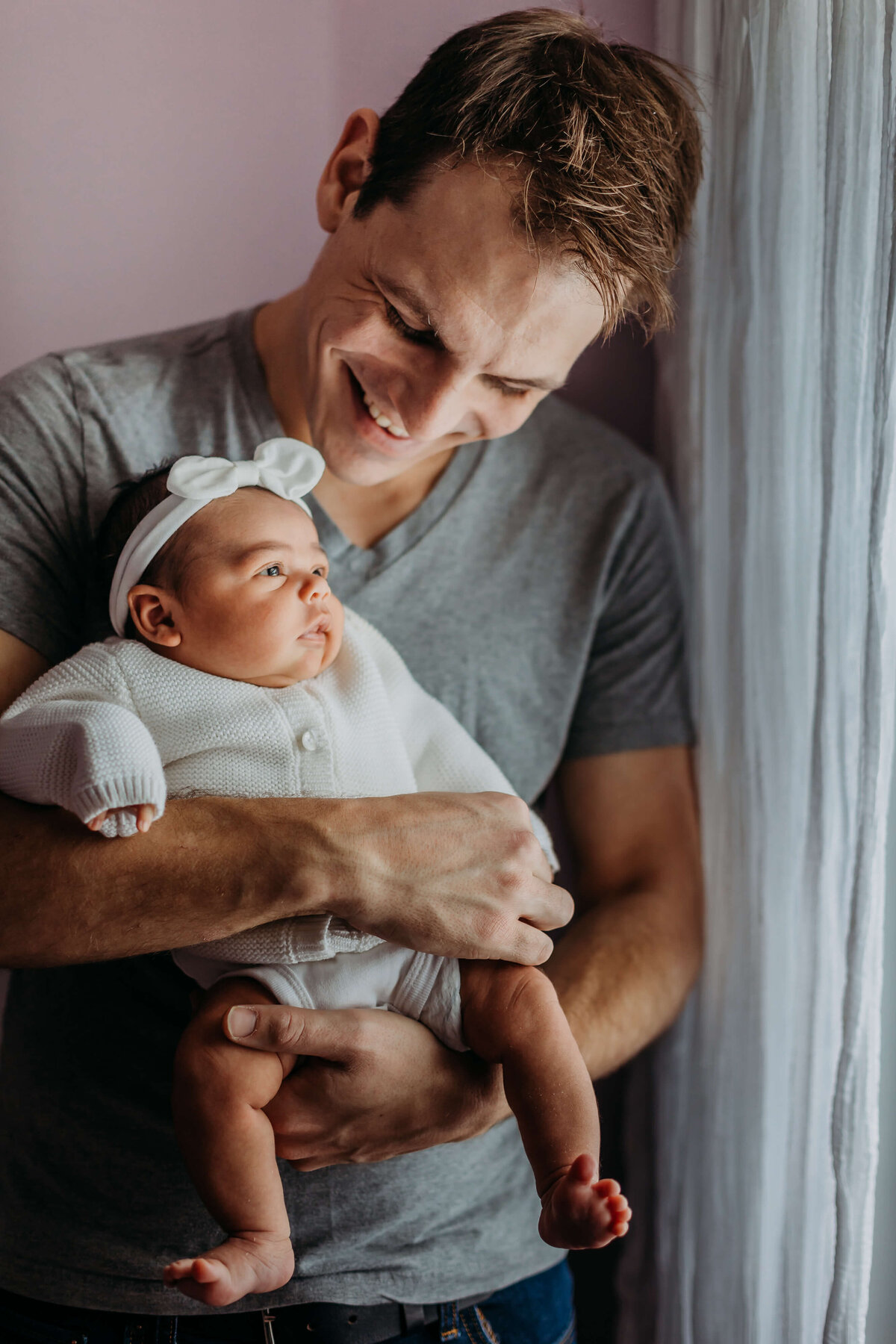 new dad holding baby in home photography session
