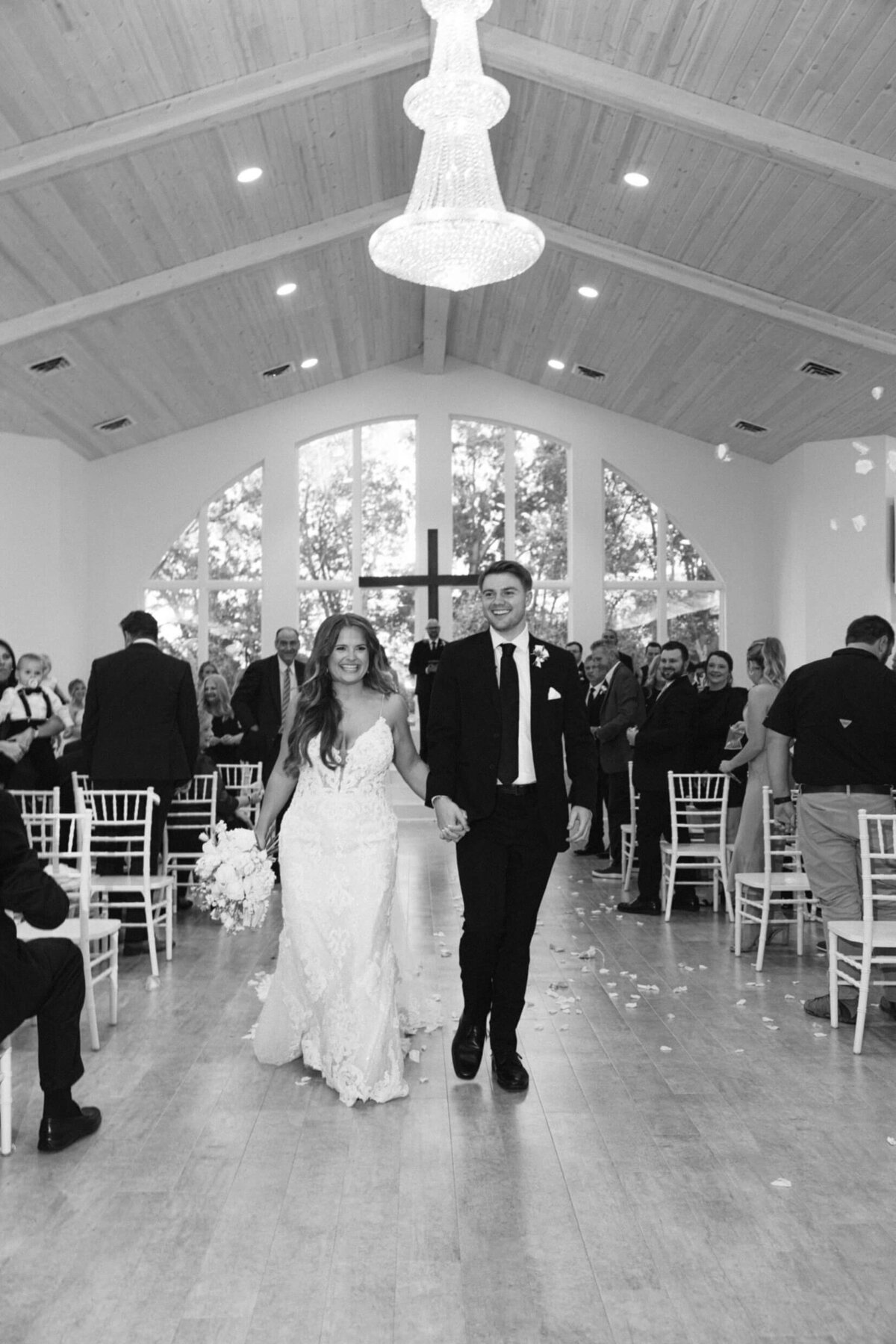 A black and white wedding photo of the bride and groom during the ceremony