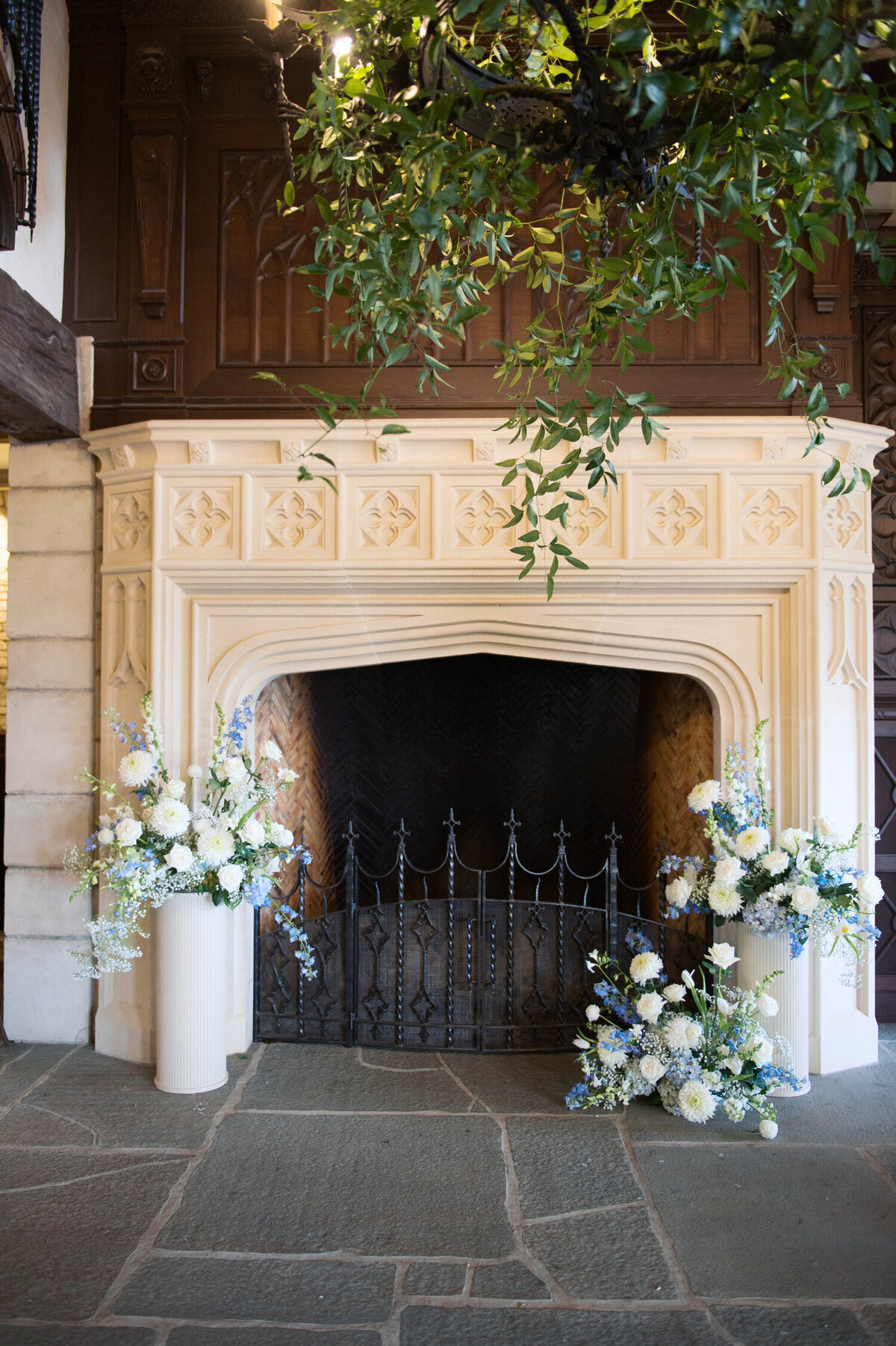 blue and white wedding flowers around fireplace at chateau de lis