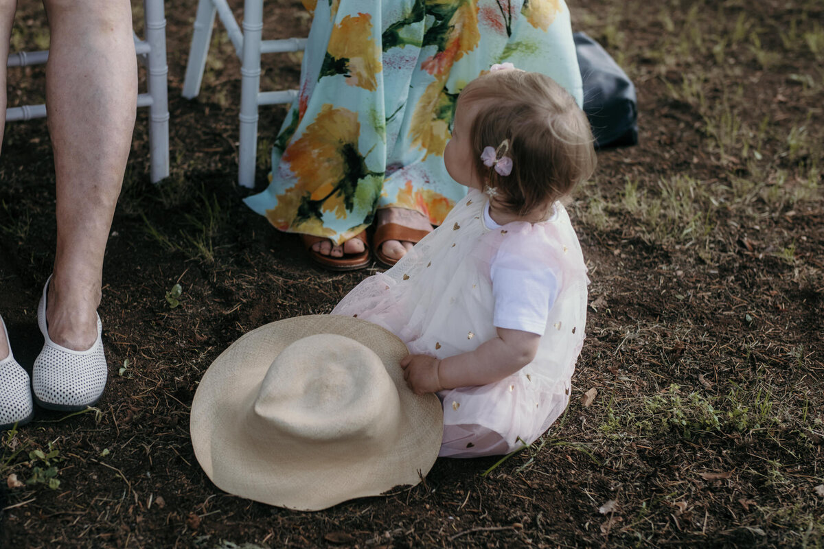 Sitting on the ground, this little child enjoyes the time during the ceremony.