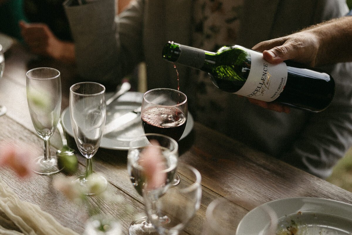 Wine being poured at the rehearsal dinner in Burgundy France at chateau Domaine du Réveillon, by Andrea-Marie Photography