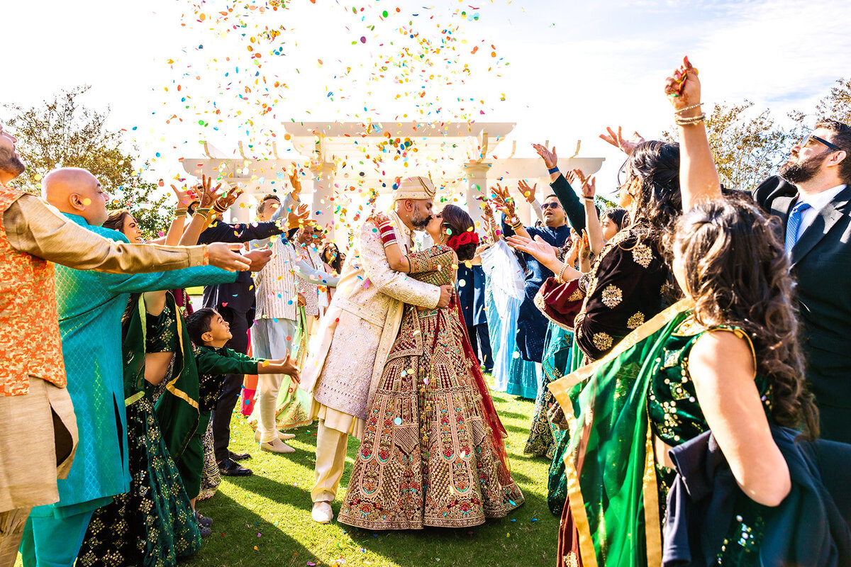 A bride and groom sharing a romantic dance under arches, illuminated by soft golden lighting, creating a dramatic and intimate moment. Captured by Shannon, an Orlando, Florida Indian Wedding Photographer.