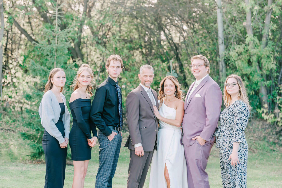 Bride and groom stand with their kids and celebrate the joining of their families.