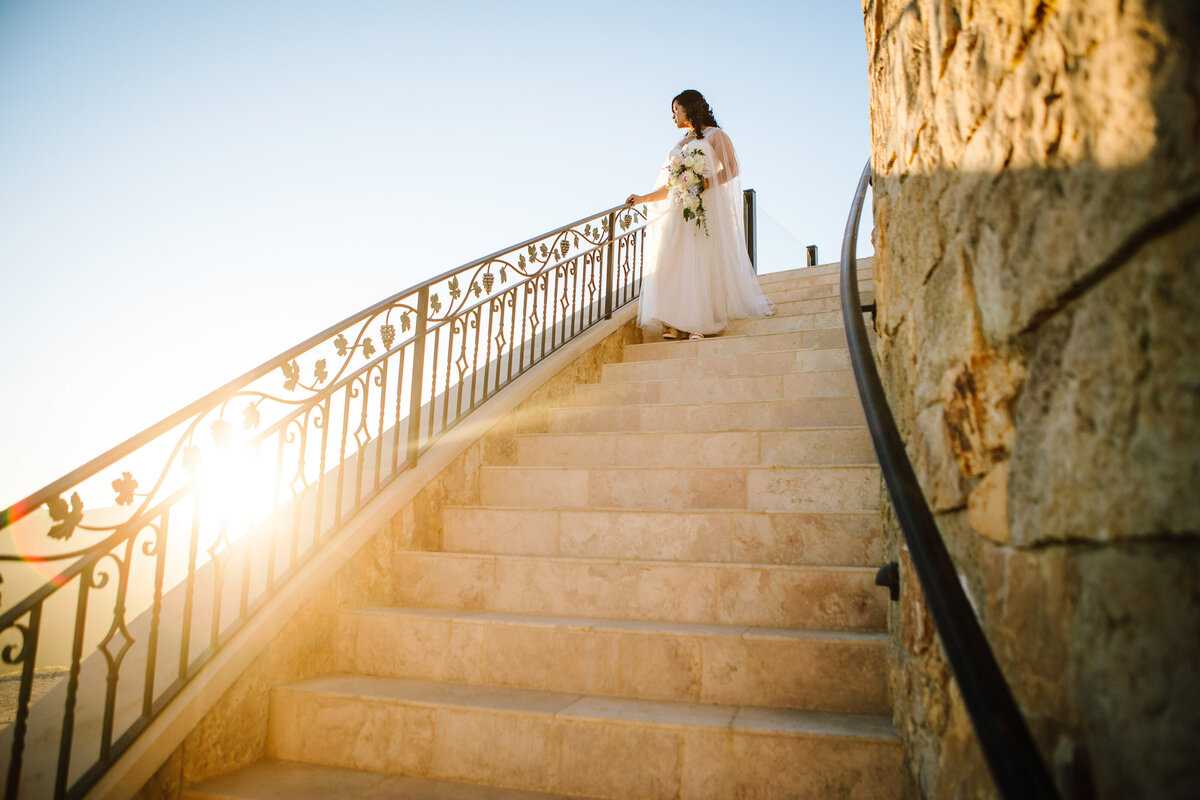bride walks down stone staircase