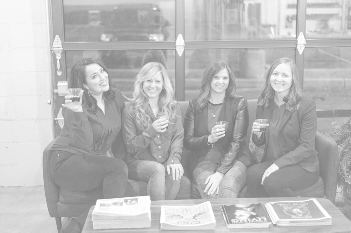Board members of the Cocktails & Chemo Foundation pose on a couch with cocktails.